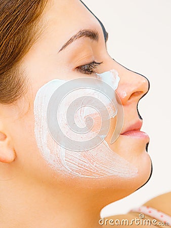 Girl black mask on half face apply white mud Stock Photo