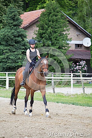 The girl in black rides a sorrel horse Stock Photo