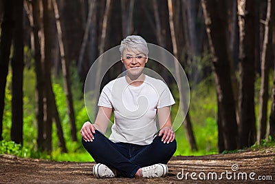 Girl blonde with short hair, resting sitting in the fir forest. Portrait of a young, beautiful, smiling girl, Stock Photo