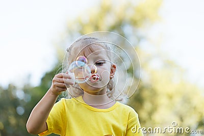 Girl Blowing Bubbles Into the Sun Stock Photo