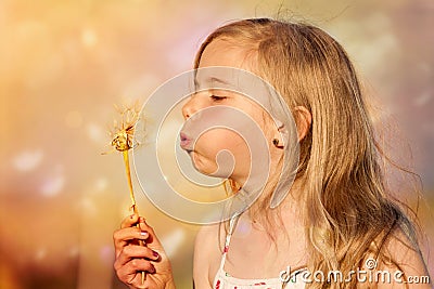 Girl blowing dandelion Stock Photo