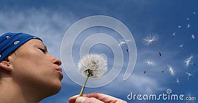 Girl blowing a dandelion Stock Photo