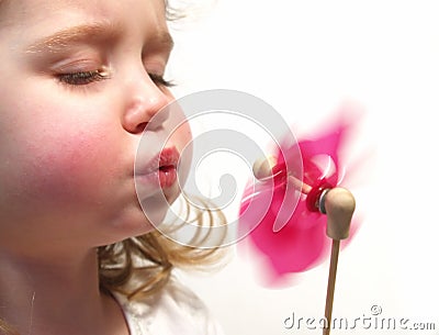 Girl blowing pinwheel Stock Photo
