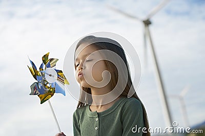 Girl Blowing Toy Windmill Stock Photo