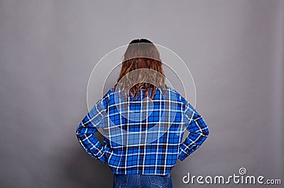 A girl in a blue shirt poses with her back to the camera Stock Photo