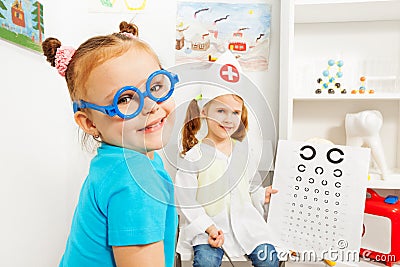 Girl in blue toy glasses at ophthalmologist room Stock Photo