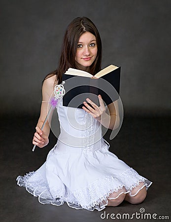 Girl with the book and a magic wand Stock Photo