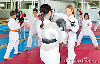 Girl launching blows on focus punch mitts Stock Photo