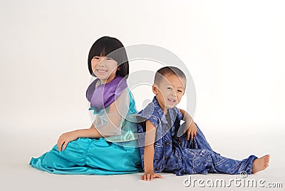 girl and boy sitting back to back Stock Photo