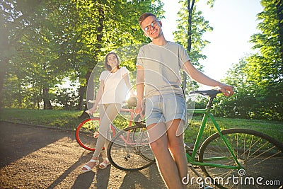 Girl And Boy Walking With Bicycle Stock Photo