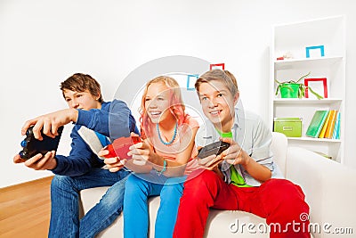 Girl and boys with joysticks playing game console Stock Photo