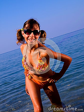 A girl in a bright bathing suit and dark glasses a Stock Photo