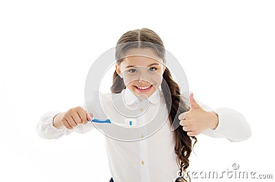 Girl brilliant perfect smile holds toothbrush with drop of paste white background. Child holds toothbrush and shows Stock Photo