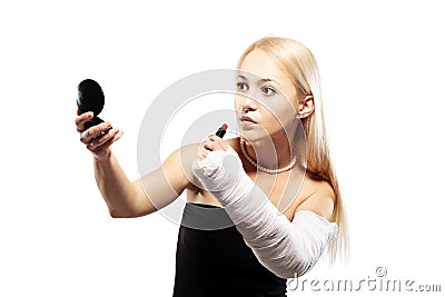 Girl with a broken arm trying to put makeup Stock Photo