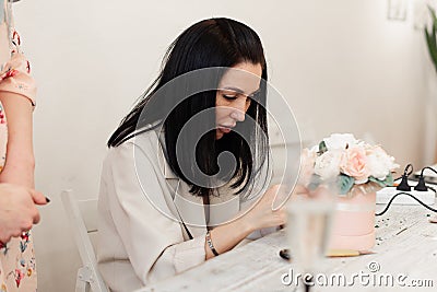 girl florist makes a bouquet of flowers on the table Stock Photo