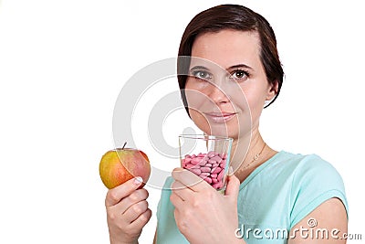 One girl holds apple and vitamins in hand Stock Photo