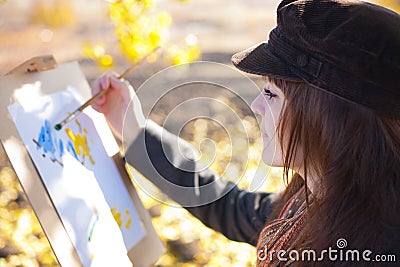 Girl with brush in hand sketches on paper Stock Photo