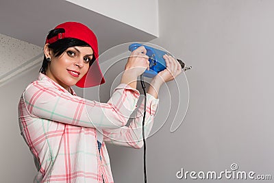 Girl builder drill wall of old drill Stock Photo