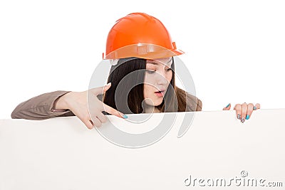 Girl builder in helmet showing a finger on a blank banner. Stock Photo