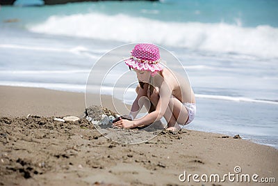 Girl building the sand castle on the beach Stock Photo