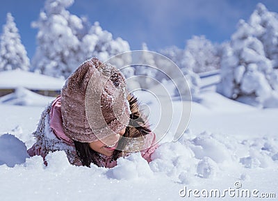 girl burried half of her body while playing outside in the snow Stock Photo
