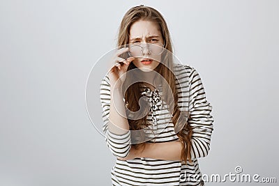 Girl cannot see clearly without glasses. Cute young teenager squinting and frowning, having bad vision, taking off Stock Photo