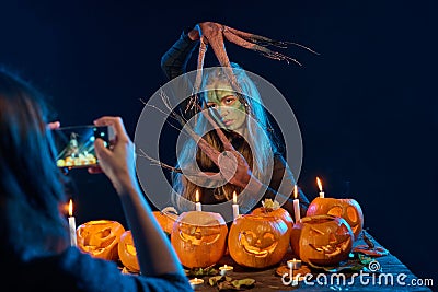 Girl capturing photo of Halloween woman with her smart phone Stock Photo