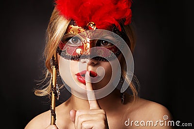 Girl with carnival mask. woman with finger on her red lips showing hush Stock Photo