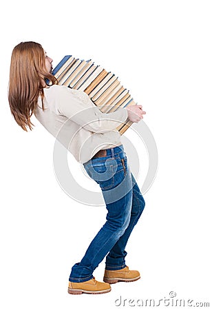 A girl carries a heavy pile of books. back view. Rear view people collection. Stock Photo