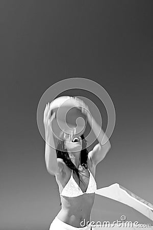 Girl catching beach ball on sunny beach in Spain. Black and white. Stock Photo