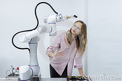 Girl caucasoid education electronic robotic arm on table at class room. learning innovation robot electronic for future AI. System Stock Photo