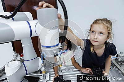 Girl caucasoid education electronic robotic arm on table at class room. learning innovation robot electronic for future AI. System Stock Photo