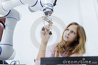 Girl caucasoid education electronic robotic arm on table at class room. Stock Photo