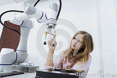 Girl caucasoid education electronic robotic arm on table at class room. learning innovation robot electronic for future AI. System Stock Photo
