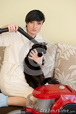 Woman clean the cat with vacum cleaner Stock Photo