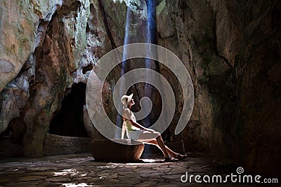 Girl in the cave under sun rays Stock Photo