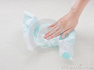 The girl checks the absorbency of a baby nappy with a napkin, close-up Stock Photo