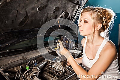 Girl checks the oil level in the car Stock Photo