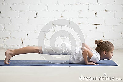 Girl child in chaturanga dandasana pose, white studio, closeup Stock Photo