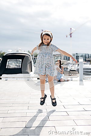 A girl child jumps high in front of her mother Stock Photo