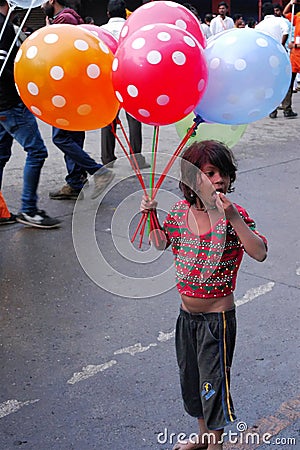 A girl child selling balloons in the street of Nasik, India. Editorial Stock Photo