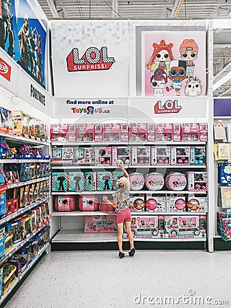 girl choosing one LOL doll in children store retailer Toys Are Us. Editorial Stock Photo