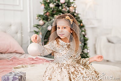 Girl with a Christmas toy in her hands. Portrait of a child with a Christmas ball Stock Photo