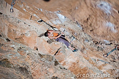 Girl climber climbs on rock. Stock Photo