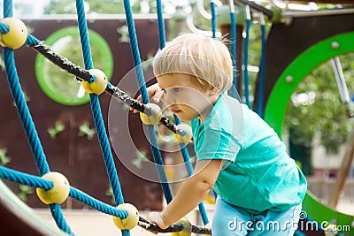 Girl climbing the ropes of challenge net Stock Photo