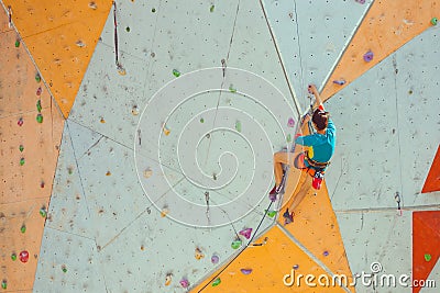 A girl climbs a climbing wall Stock Photo
