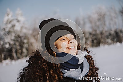 Girl with closed eyes enjoying the tranquility and loneliness of a winter forest Stock Photo