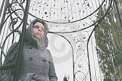 Girl in a coat posing outside in the autumn in gloomy weather, peering thoughtfully into the distance. the concept of autumn depre Stock Photo