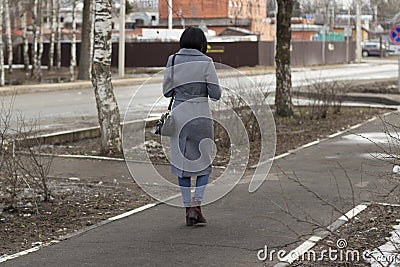 The girl in the coat is walking along the door Editorial Stock Photo