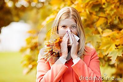 Girl with cold rhinitis on autumn background. Fall flu season. I Stock Photo